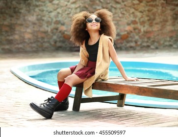 African American  Little Girl Wearing Stylish Clothes By The Pool. Fashion Kid Concept