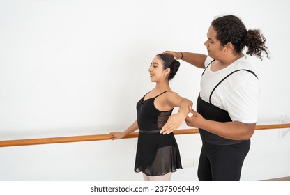 african american male ballet dancer instructor teaching and training a young student hispanic ballerina, learning new skills - Powered by Shutterstock