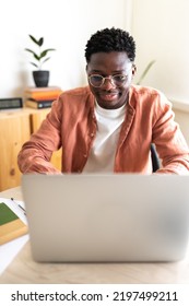 African American Male College Student Studying At Home Using Laptop. Vertical Image.