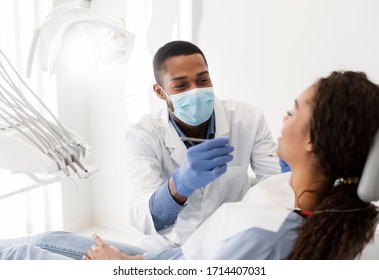 African american male dentist making treatment in modern clinic - Shutterstock ID 1714407031