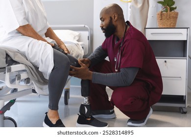 African american male doctor examining senior caucasian female patient with prosthetic leg. Hospital, disability, work, medicine and healthcare, unaltered. - Powered by Shutterstock