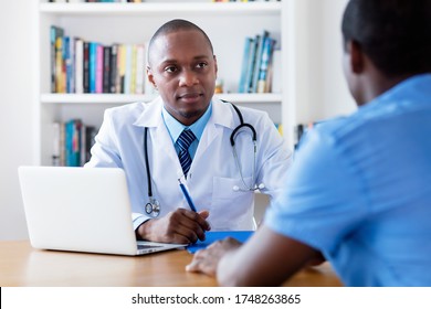 African American Male Doctor Listening To Infected Patient At Hospital