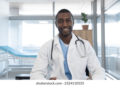 African american male doctor wearing lab coat and stethoscope, having video call at hospital. Hospital, communication, video call, medicine, healthcare and work, unaltered. - Powered by Shutterstock