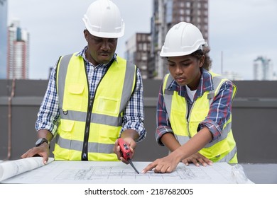 African American male engineer and woman engineer worker working with construction building blueprint at construction site. Group of African American construction worker and building blueprint - Powered by Shutterstock