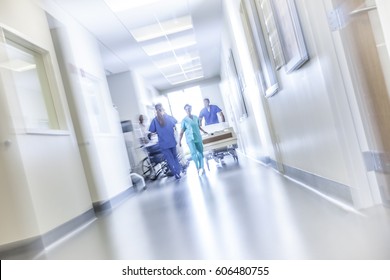 African American Male Female Medical Nursing Staff With Hospital Bed In Specialist Care Corridor Motion Blur