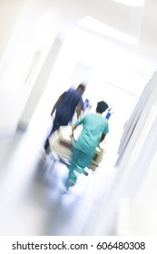 African American Male Female Nursing Staff In Uniform Scrubs With Hospital Bed In Modern Healthcare Centre Motion Blur