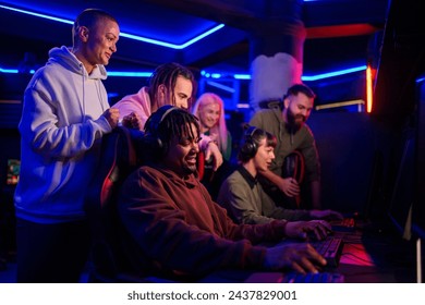 African american male gamer playing PC video game and having fun with his friends. Black male video game player playing with his multiracial team in a Esports arena or on a Gaming convention. - Powered by Shutterstock