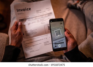 African American Male Hands, Left Hand Holding The Bill, Right Hand Holding A Mobile Phone With QR Payment App On The Screen, Scanning QR Code