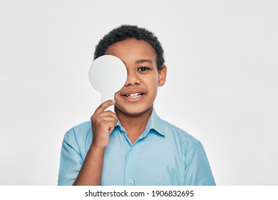 African American Male Kid Having Eye Exam With One Eye Covering Using An Ophthalmic Tool, On White Background