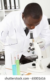 African American Male Lab Researcher Looking Through Microscope