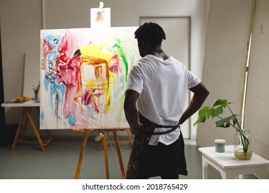 African american male painter at work looking at artwork in art studio. creation and inspiration at an artists painting studio. - Powered by Shutterstock