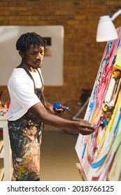 African American Male Painter At Work Painting On Canvas In Art Studio. Creation And Inspiration At An Artists Painting Studio.