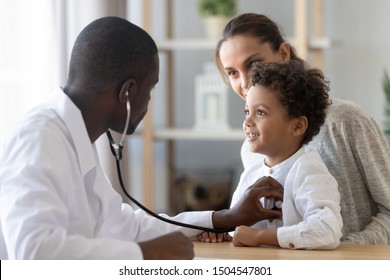African American male pediatrician with stethoscope listening to lung and heart sound of little boy sitting on mother lap, physician checkup at home or in hospital, children medical insurance care - Shutterstock ID 1504547801