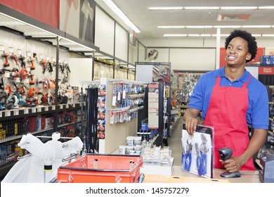 African American Male Store Clerk At Checkout Counter In Super Market