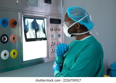 African american male surgeon studying x-ray on lightbox in operating theatre. Hospital, medical and healthcare services. - Powered by Shutterstock