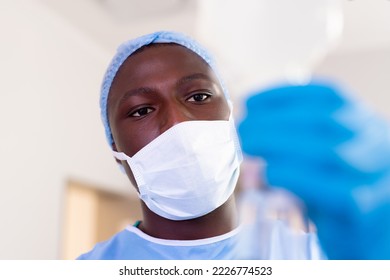 African american male surgical tech preparing iv fluid bag in operating theatre, with copy space. Hospital, medical and healthcare services. - Powered by Shutterstock