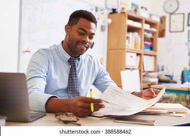 African American Male Teacher Working At His Desk