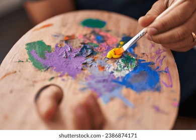 African american man artist mixing color on palette at art studio - Powered by Shutterstock