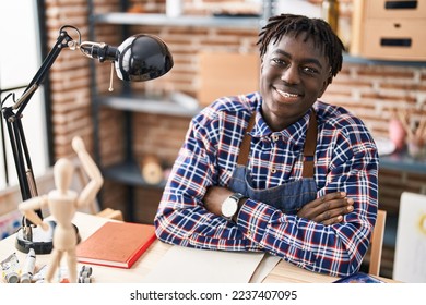 African american man artist smiling confident sitting with arms crossed gesture at art studio - Powered by Shutterstock