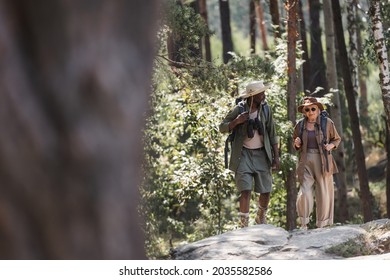 African American Man With Backpack And Binoculars Hiking With Senior Wife In Forest