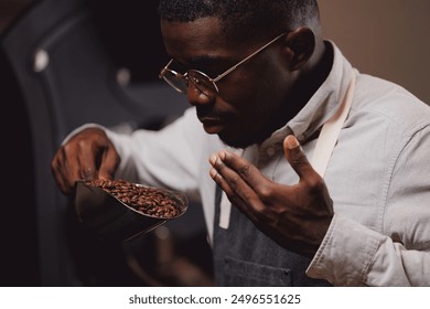 African american man barista testing aroma of fresh coffee beans after roasting machine industry, small business cafe. - Powered by Shutterstock