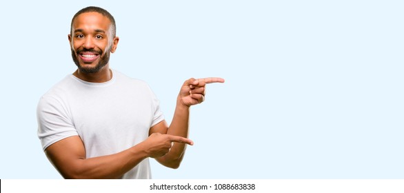 African american man with beard pointing away side with finger isolated over blue background