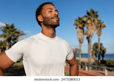 African American man breathing deeply in nature. Black man in sports clothing feeling good after exercising. Relaxation and sport concepts. - Powered by Shutterstock