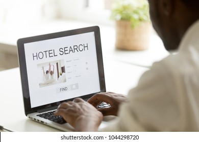 African american man browsing hotel online for business or holiday vacation using web search app on laptop computer website engine, black businessman looking for cheap booking service, rear close up - Shutterstock ID 1044298720