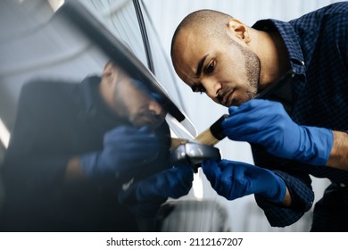 African American man car service worker applying nano coating on a car