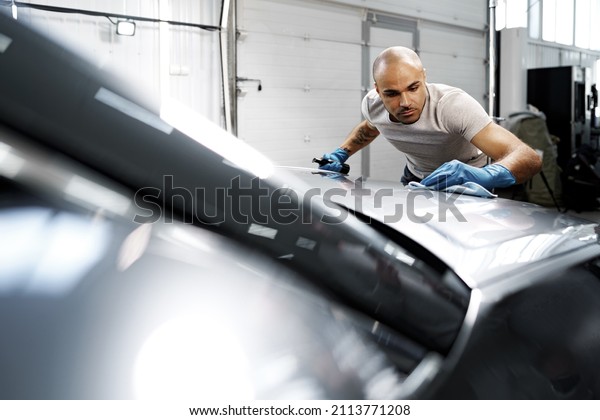 African American man car service worker applying nano
coating on a car