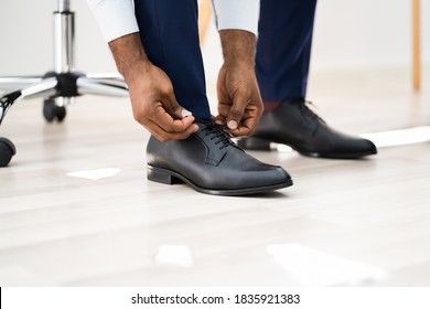 African American Man Changing Shoes At Office Floor