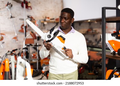 African American Man Chooses Chainsaw At A Garden Tool Store