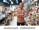 A african american man chooses a power tool in a hardware store.