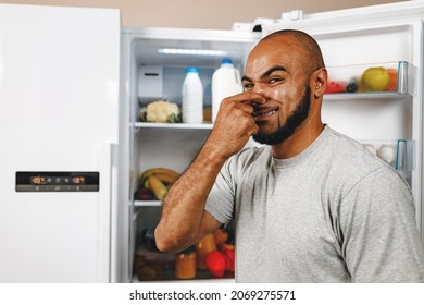 African American Man Closing Nose Because Of Bad Smell From Fridge