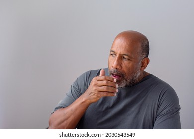 African American man coughing into his hand. - Powered by Shutterstock