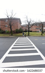 An African American Man Crossing The Road. A Black Man Walking On The Zebra Crossing. Road Safety. Winter And Cold