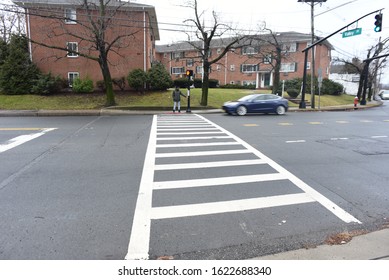 An African American Man Crossing The Road. A Black Man Walking On The Zebra Crossing. Road Safety. Winter And Cold