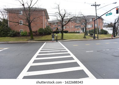 An African American Man Crossing The Road. A Black Man Walking On The Zebra Crossing. Road Safety. Winter And Cold