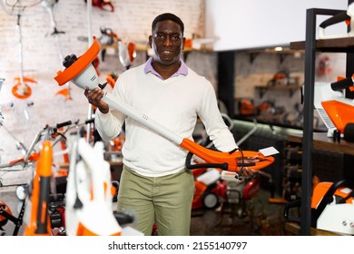 African American Man Demonstrates Garden Trimmer In A Garden Equipment Store