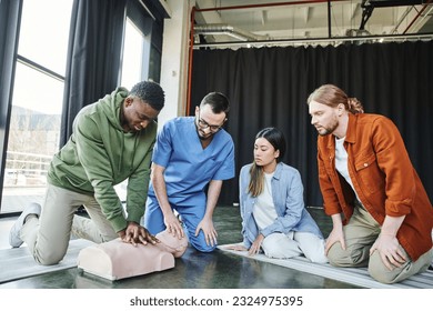 african american man doing chest compressions on CPR manikin during hands-on learning on first aid seminar near professional paramedic and diverse group of young multiethnic participants - Powered by Shutterstock