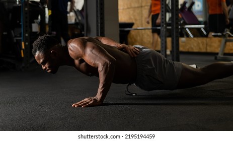 African american man doing one arm push ups in the gym.  - Powered by Shutterstock