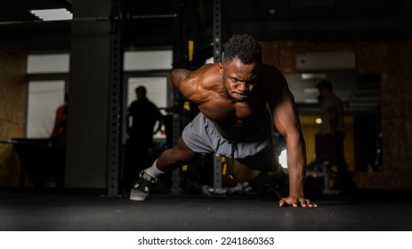 African american man doing one arm push ups in the gym.  - Powered by Shutterstock