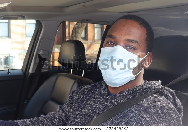 \
African\
American Man Driving car wearing medical\
mask