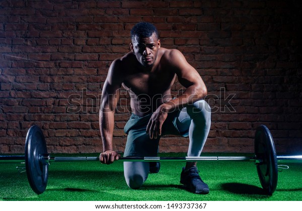 Shirtless fit young man stretching at outdoors gym 