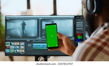 African american man edits a music video at his home office next to copy space screen, using editing software and dual monitors. Solving video production and freelancing tasks. Camera B. - Powered by Shutterstock