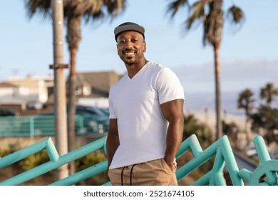 African American man enjoying Venice beach, smiling man in white t-shirt, African American man standing outdoor wearing t-shirt, man with casual t-shirt on street - Powered by Shutterstock