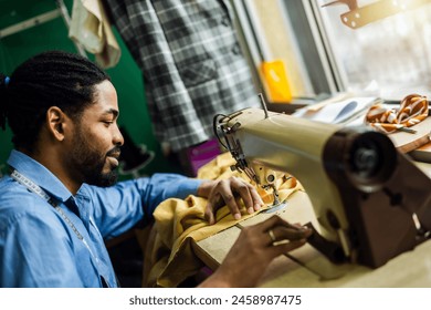 African American man fashion designer sewing on a vintage sewing machine. - Powered by Shutterstock