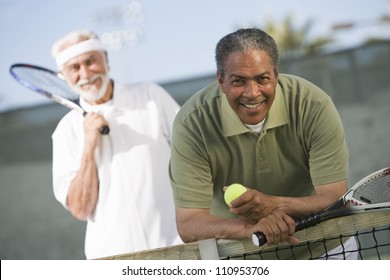 African American man with a friend playing tennis - Powered by Shutterstock