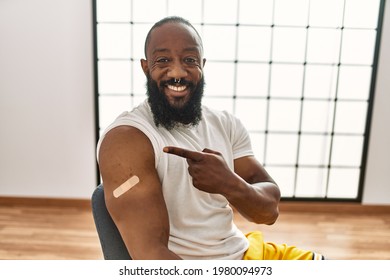 African American Man Getting Vaccine Showing Arm With Band Aid Smiling Happy Pointing With Hand And Finger 