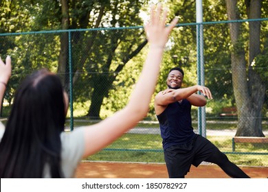 African American Man With Girl Plays Basketball On The Court Outdoors.